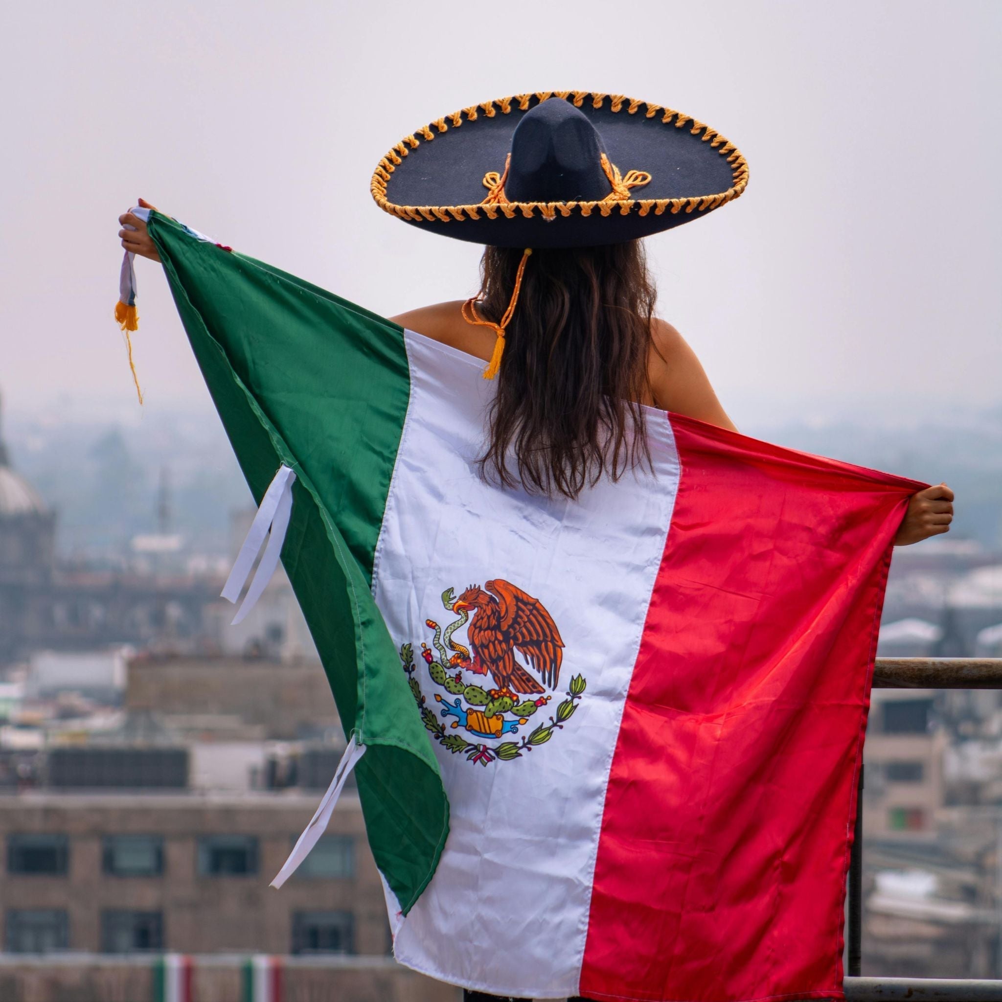 Woman in Mexico holding a large Mexican flag