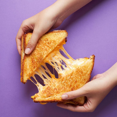 Birria grilled cheese sandwich with melted cheese and beef, dipped into consommé.