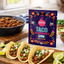 Spicito taco seasoning packet with tacos and ingredients on a wooden board.